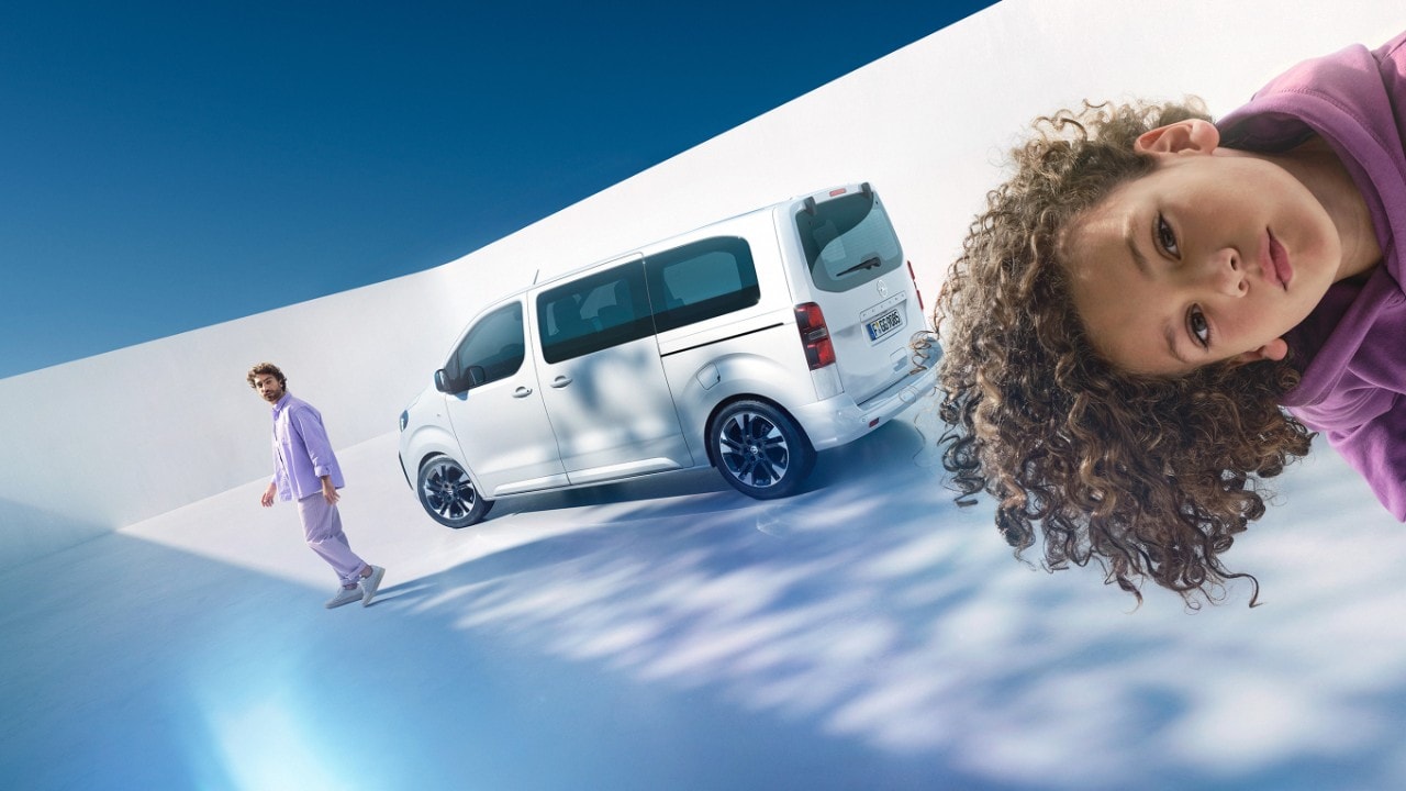 Man en jongen naast witte Opel Zafira op de achtergrond